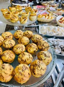 a buffet filled with pies and muffins on plates at Hotel Lux in Poços de Caldas