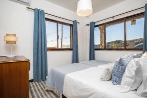 1 dormitorio con 1 cama y 2 ventanas en White Rabbit II by Madeira Sun Travel, en Calheta