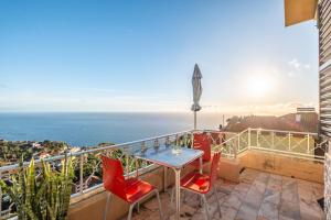 balcón con mesa, sillas y vistas al océano en White Rabbit II by Madeira Sun Travel, en Calheta