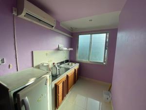 a purple kitchen with a sink and a refrigerator at Phuket Latika Mansion by Andaman Home in Phuket Town