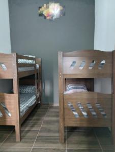 2 houten stapelbedden in een kamer bij Cantinho do Sossego - kitnets in Cananéia