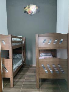 2 Etagenbetten aus Holz in einem Zimmer in der Unterkunft Cantinho do Sossego - kitnets in Cananéia
