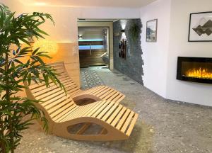 two wooden benches in a room with a fireplace at Landhaus Obermaiselstein "THE VIEW" in Obermaiselstein