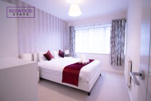 a white bedroom with a bed and a window at Festival Place, Modern Town Center Apartment, Perfect for Contractors & Families, FREE Parking & WiFi by REDWOOD STAYS in Basingstoke