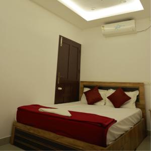 1 dormitorio con 1 cama grande con almohadas rojas en LOVESHORE Homestay en Kollam