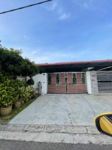 ein Haus mit einer Garage mit einer Tür in der Unterkunft three bedroom tarraced house - RainaHomestay Pasir Gudang in Pasir Gudang