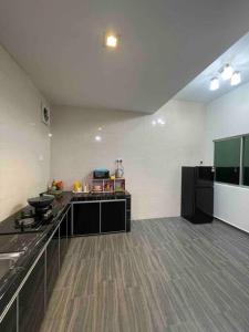 eine große Küche mit einer Theke und einem Kühlschrank in der Unterkunft three bedroom tarraced house - RainaHomestay Pasir Gudang in Pasir Gudang