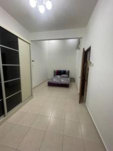 three bedroom tarraced house - RainaHomestay Pasir Gudang في باسير غونداغ: ممر طويل مع أريكة في الغرفة