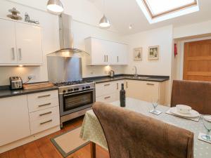 a kitchen with a table and a stove top oven at Wellington Lodge Cottage in Richmond