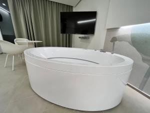 a white toilet in a room with a tv at Seacity Suite & Stay in Monopoli +48 photos