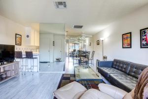a living room with a couch and a tv and a table at Walk to Dtwn Palm Springs Condo with Pool Access in Palm Springs