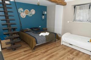 a bedroom with a bed and a spiral staircase at Belle Maison tourangelle pour 6 personnes in Chambourg-sur-Indre