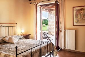 a bedroom with a bed and a door to a patio at Podere Cascatelle&Agriletizia - Cascate Naturali in Massa Marittima