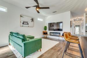 a living room with a green couch and chairs at Modern Pensacola Vacation Home with Private Pool! in Pensacola