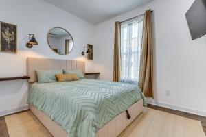 a bedroom with a bed with a mirror and a window at Modern Pensacola Vacation Home with Private Pool! in Pensacola