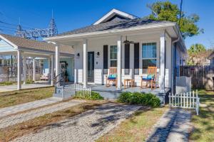 a white house with two chairs on a porch at Modern Pensacola Vacation Home with Private Pool! in Pensacola