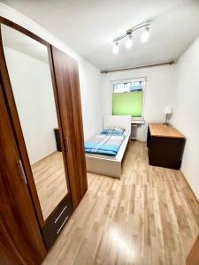 Habitación pequeña con cama y escritorio. en Ida, the suburban apartment nearby Cologne, en Bergheim