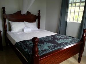 Corosol Apartments في روسو: سرير مع اللوح الأمامي الخشبي وشراشف ومخدات بيضاء