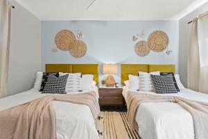 two beds in a room with white walls at Phoenix Haven - Modern 4BR - Fire pit - Retreat - Golf in Phoenix