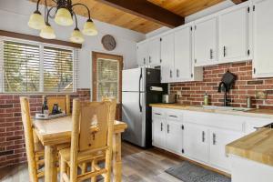 uma cozinha com armários brancos e uma parede de tijolos em Alta Vista Haus in Moonridge em Big Bear Lake