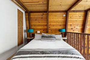 um quarto com uma cama num quarto com paredes de madeira em Alta Vista Haus in Moonridge em Big Bear Lake