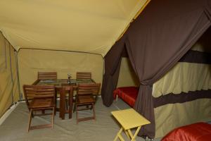 a tent with a table and chairs in it at Prêts-à-camper Camping Tadoussac in Tadoussac