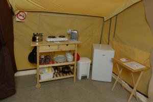 a small tent with a table and a refrigerator at Prêts-à-camper Camping Tadoussac in Tadoussac