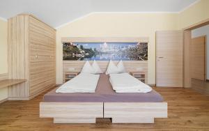 a bedroom with a large bed with white pillows at Luxus-Appartements Fosensteiner in Ramsau am Dachstein