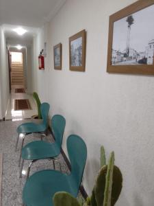 duas cadeiras verdes e uma planta num quarto em Hostel Arena Prime em Salvador