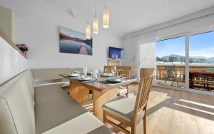 a kitchen and dining room with a table and chairs and a view at Luxus-Appartements Fosensteiner in Ramsau am Dachstein