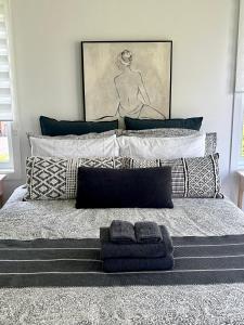 - une chambre avec un lit avec des oreillers et un tableau dans l'établissement Oasis by the River, à Saint-Irénée