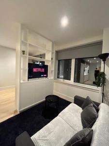 een woonkamer met een bank en een tv bij LUXX Apartment & Suites, London Heathrow Airport, Terminal 4, Piccadilly underground Train station nearby! in New Bedfont