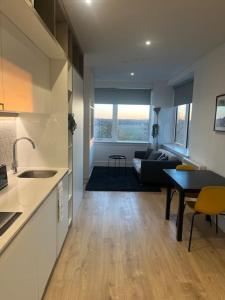 een keuken en een woonkamer met een bank en een tafel bij LUXX Apartment & Suites, London Heathrow Airport, Terminal 4, Piccadilly underground Train station nearby! in New Bedfont