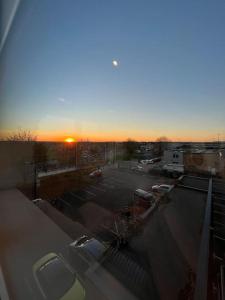 a parking lot with a sunset in the background at LUXX Apartment & Suites, London Heathrow Airport, Terminal 4, Piccadilly underground Train station nearby! in New Bedfont