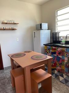 Il comprend une cuisine équipée d'une table en bois et d'un réfrigérateur. dans l'établissement Apartamento encantador cachoeira, à Florianópolis