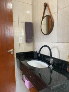 uma casa de banho com um lavatório e um espelho em Apartamento encantador cachoeira em Florianópolis
