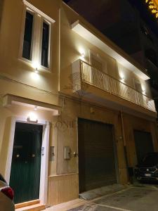 un edificio con una puerta verde y un balcón en Peonies' Home, en Francavilla Fontana