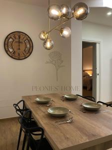 mesa de comedor con sillas y reloj en la pared en Peonies' Home, en Francavilla Fontana