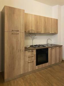 cocina con armarios de madera y fogones en Peonies' Home, en Francavilla Fontana