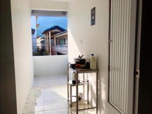 a hallway with a table and a view of a house at Phuket House and Home Apartment in Ban Huai Luk (1)