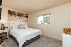 um quarto com uma cama branca e uma janela em La Hacienda Grande em Santa Maria