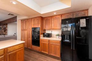 a kitchen with wooden cabinets and black appliances at La Hacienda Grande in Santa Maria