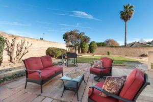 a patio with red chairs and a table and a brick wall at La Hacienda Grande in Santa Maria +5 photos