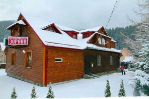 a building with snow on the roof of it at Zoriana in Tatariv