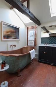 baño grande con bañera grande y lavamanos en The Pear Tree Inn en Bury Saint Edmunds