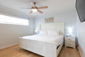 a white bedroom with a white bed and a ceiling fan at Ocean View Hideaway Unit #3 in San Clemente