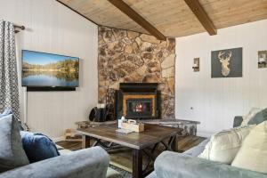 a living room with a fireplace and a stone wall at Chateau Oso Grande in Big Bear in Big Bear City