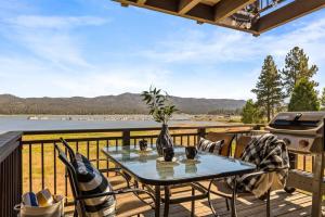 a table and chairs on a deck with a view of the water at Lakefront at the Village in Big Bear Lake