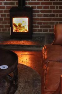 sala de estar con sofá y chimenea en The Pear Tree Inn en Bury Saint Edmunds