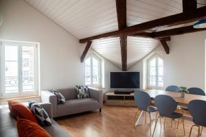 een woonkamer met een tafel en stoelen en een televisie bij Nimbuzzz Apartments in Unterseen